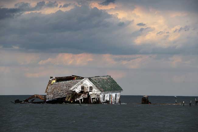 The last house on Holland Island in Chesapeake Bay, which once had a population of almost 400,  finally toppled in October 2010. As the water rose and the island eroded, it had to be abandoned. Astrid Riecken for The Washington Post, via Getty Images